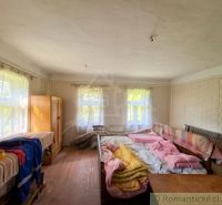 Traditional interior of a family house with beds and windows with delicate curtains.