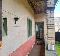 Entrance porch to a family house in Dobroč with a wooden decor and a brick wall.