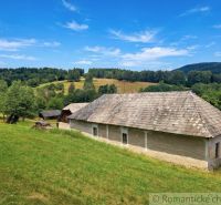 A family house in Dobroč with a wooden roof surrounded by nature and meadows.