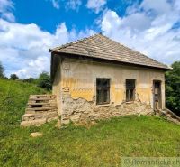 Old stone family house in Dobroč with damaged plaster and a tile roof.