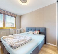 A bedroom in a 3-room apartment with a bed, a mirrored wardrobe, and a floor with a wooden decor.