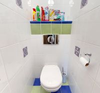 A bathroom in a three-room apartment with tiles decorated with colorful patterns on the walls.