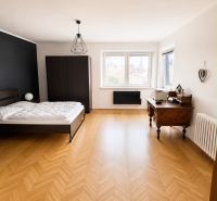 A bedroom with a bed, wardrobe, and wooden decor flooring in a 3-room apartment.