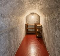 A hallway space with a vaulted ceiling and red floor, part of a 3-room apartment.