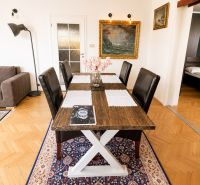 Dining area in a three-room apartment with a wooden decor floor and a carpet.