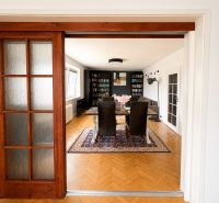 Sliding doors lead to the living room with a wood-patterned floor in a 3-room apartment.