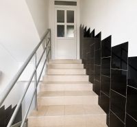 A staircase in a 3-room apartment with dark walls and railing.