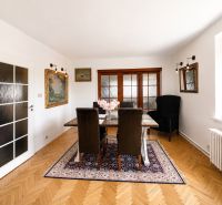 Dining room in a 3-room apartment with a wooden decor floor and decorative elements.