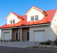 A family house in Andovce with a sloped red roof and white facade.