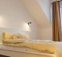 A bedroom in a family house with attractive lighting and a comfortable bed.