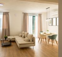 Living room with a corner sofa and a dining table on a floor with a wooden decor.