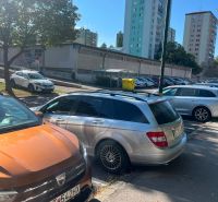 Parking lot on Púpavova Street, Karlova Ves district, with high-rise buildings.