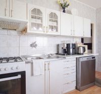 A kitchen in a 4-room apartment with a gas stove and white cabinets.