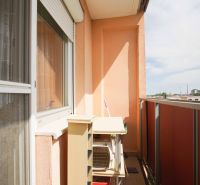 The balcony of a 4-room apartment in Nové Zámky with a view of the city and concrete panels.