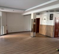 Commercial space with a wood-patterned floor and decorative clock on the wall.