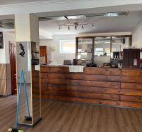 A café with a bar counter and a wooden decor floor in commercial premises.