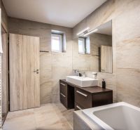 Bathroom in a 2-room apartment with light tiles, a mirror, and a sink.