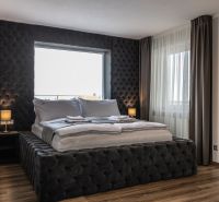 Bedroom in a 2-room apartment with a bed and a wooden decor floor.