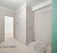 Bare walls in an unfinished 2-room apartment without completed flooring and doors.