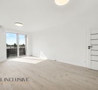 A bright room in a 2-room apartment with a wooden decor floor and large windows.