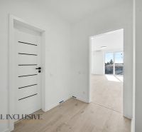 Interior of a 2-room apartment with a wooden decor floor and white doors.