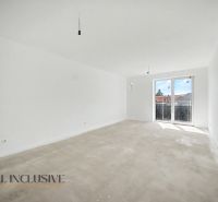 A spacious room in a 2-room apartment with large windows and a wooden decor floor.