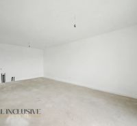 Empty room in a 2-room apartment with white walls and a concrete floor.