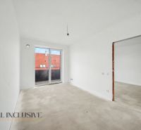 Empty rooms in a 2-room apartment with large windows and a view of the rooftops.