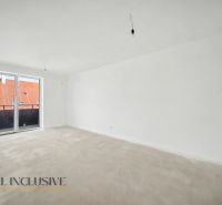 A spacious room in a 2-room apartment with a large window and concrete floor.