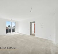 A spacious interior in an unfinished state with light walls and large windows in a 2-room apartment.
