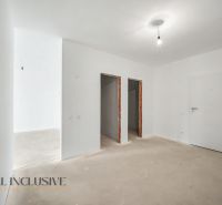 A white interior of a 2-room apartment with bare walls and ceiling lighting.