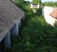 An older building with mature vegetation on the premises - housing on L. G. Zaoseka Street, Banská Bystrica.