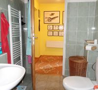Bathroom in a family house with a sink, towels, and wall decoration.