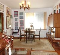 A living room in a family house with a wooden decor floor and paintings on the walls.