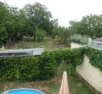 The garden behind the family house on Tretí rad Street in the village of Mojmírovce with a pool and greenery.
