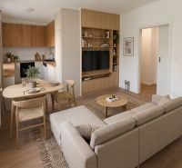 Living area with a built-in kitchen and a wooden decor floor in a 4-room apartment.