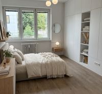 Bright bedroom with a built-in wardrobe and bed in a 4-room apartment, floor with wood decor.