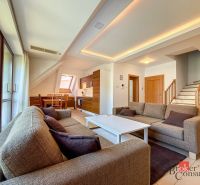 Living room with a sofa, dining table, staircase, wooden decor flooring in a 5 or more room apartment.