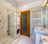 A bathroom in a 5 or more room apartment with a shower, washing machine, and dryer.