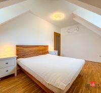 A bedroom with a wood-patterned floor and simple furniture in a 5 or more room apartment.