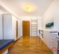 A room with a wooden decor floor, fully furnished, in a 5 or more bedroom apartment.