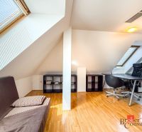 Attic room with a wooden decor floor, a desk, and a sofa in a 5 or more room apartment.