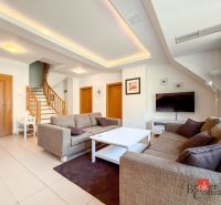 Living room with wood-patterned flooring, staircase, and sofa in a 5 or more room apartment.