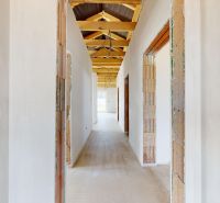 A hallway in a family house with a view of the wooden ceiling beams.