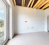 Interior of a family house with a large window, ceiling beams, and a floor with a wood decor.