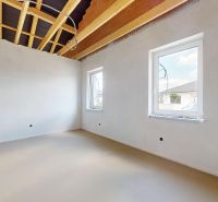 A place in a family house with white walls and an unfinished ceiling, two windows.