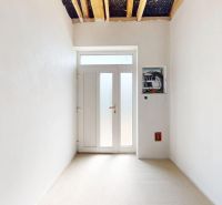 Hallway in a family house with white walls and large doors.