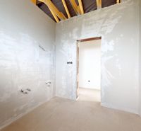 A room construction in a family house with visible wiring and roof beams.