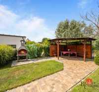 A gazebo with a garden fireplace by the cottage in Vojka nad Dunajom, surrounded by greenery and lawn.