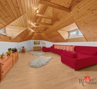 Attic interior of a cottage with a sofa set and wooden decor flooring.